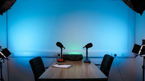 Studio set with blue lighting and two empty seats at a table