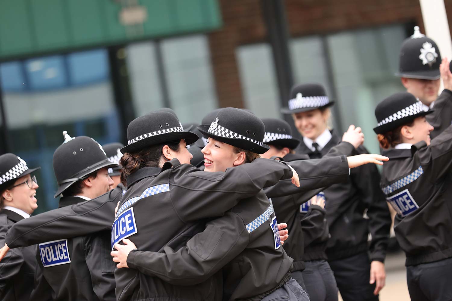 Police officers hugging after passing out parade.