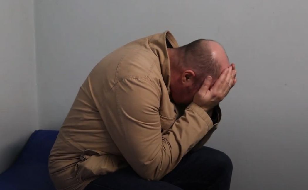 Drink driver in cell with head in hands