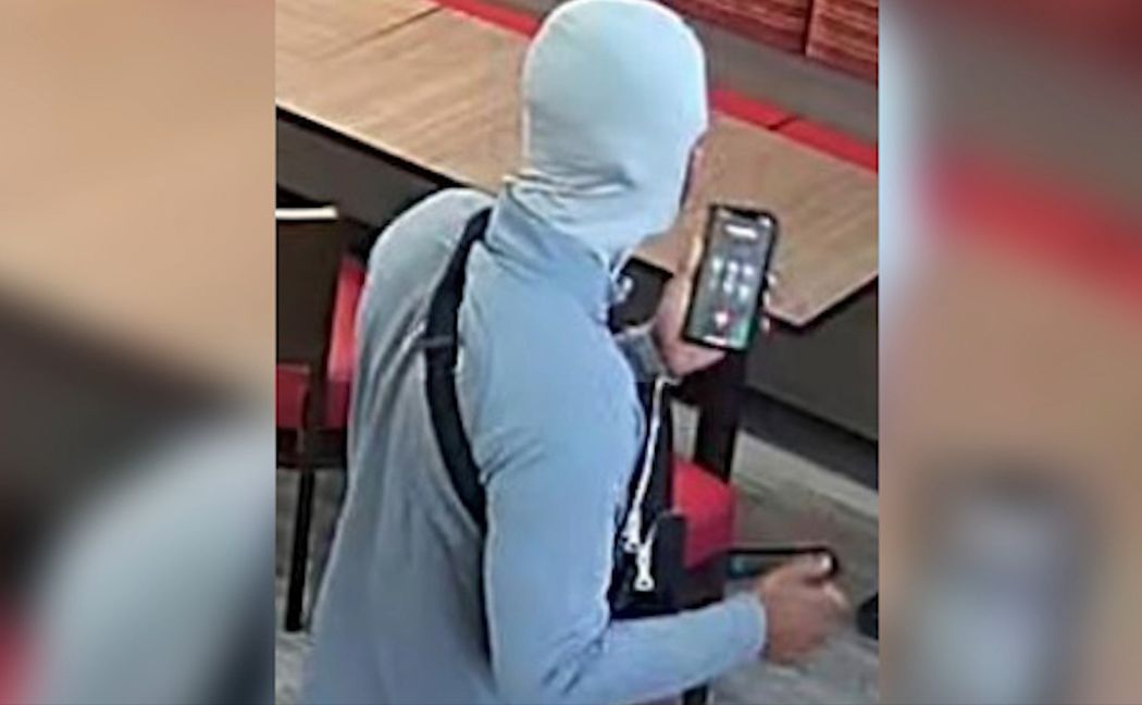 Violent gang member on phone on CCTV