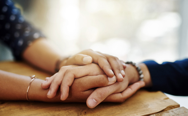 People holding hands to provide comfort