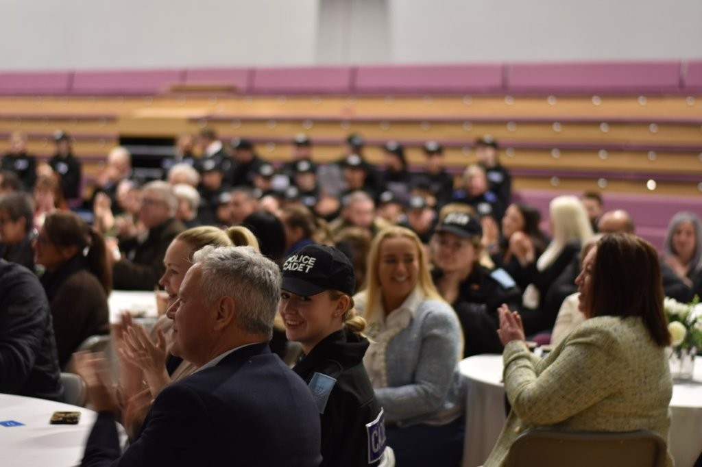 A crowd of people sat at tables at an awards ceremony.