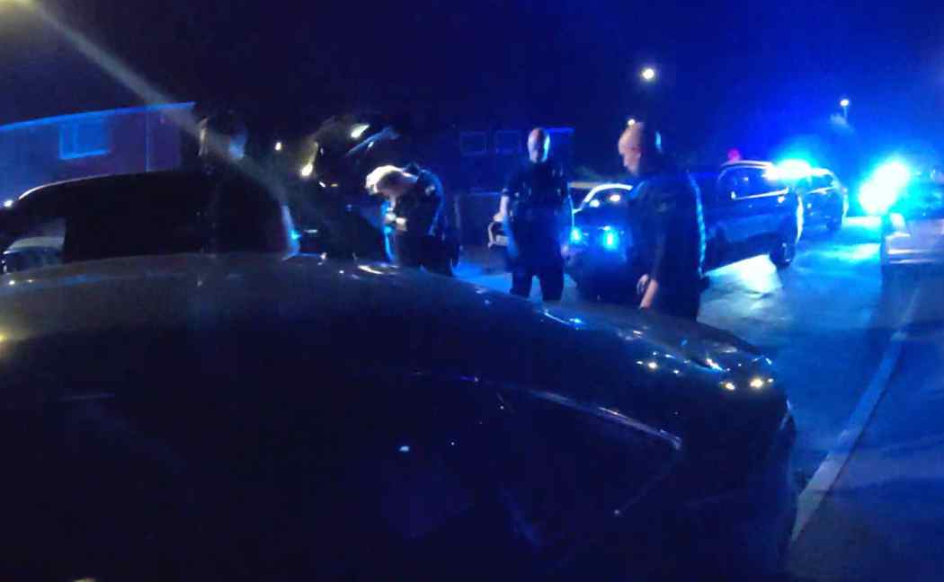 Blue lights flash as officers arrest a suspect