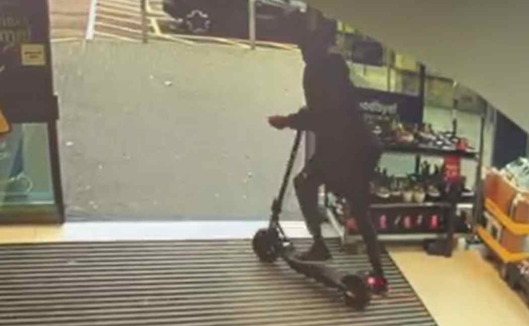 Joe Edwards rides a stolen scooter out of a shop