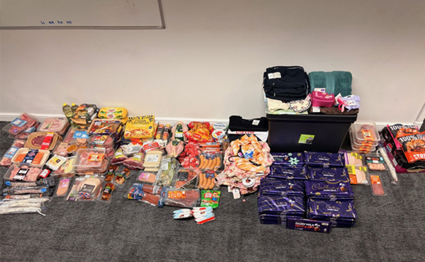 Supermarket stock including clothes and food piled against a wall in a police station after it was seized.