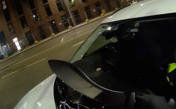 A machete pictured on the bonnet of a police car. It is night time.