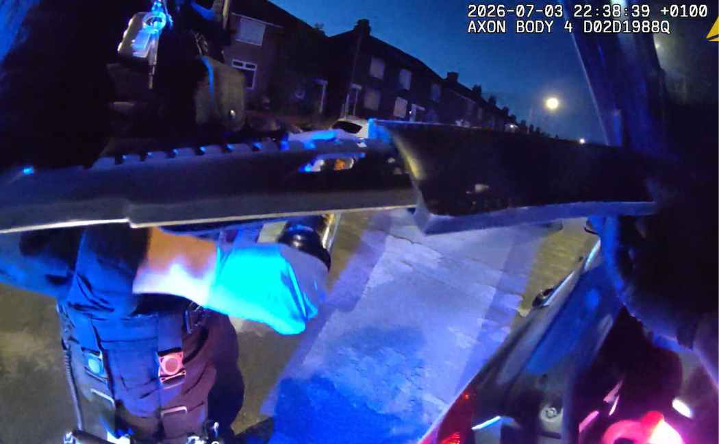 Officers recover a machete from the rear of the vehicle