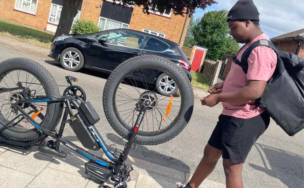 Man standing next to upended e-bike