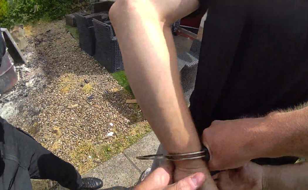Bodycam screenshot of man in handcuffs