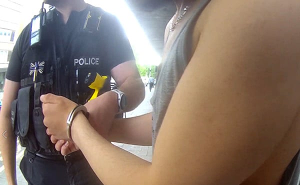 A man being arrested by a police officer