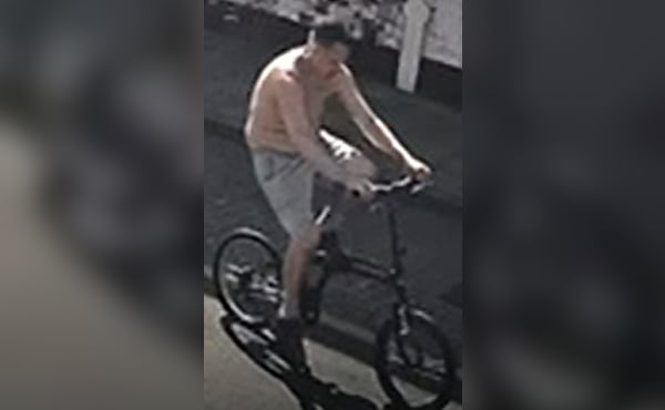 A CCTV image of a man riding a bike who police want to identify