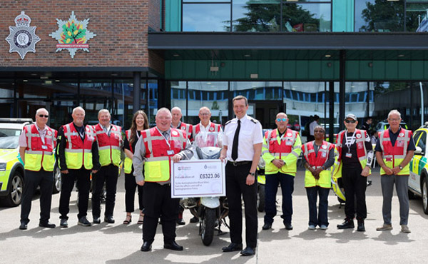 Nottinghamshire Police Chief Constable Steve Cooper presents a cheque to the Nottinghamshire Blood Bikes charity