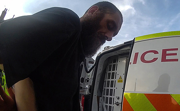 A still image showing arrested shop thief Kashley Michael being put into the back of a police van