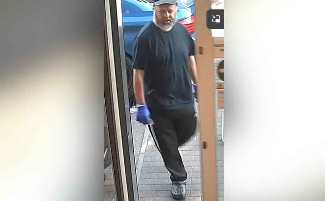 Man wearing hat walks through door