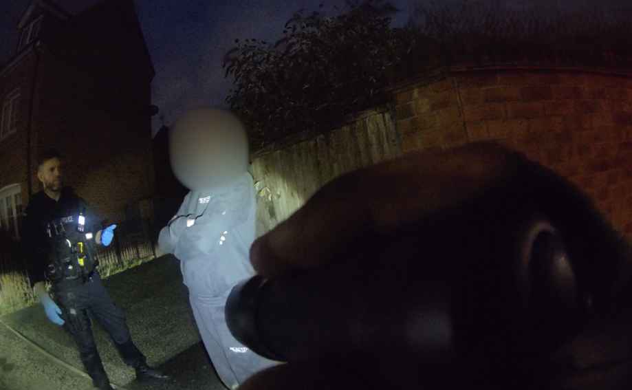 Officer shines torch at suspect