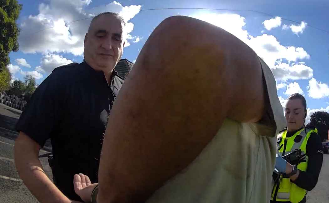Two officers place suspect in handcuffs